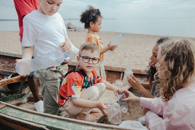 niños en la playa contribuyendo con el medio ambiente